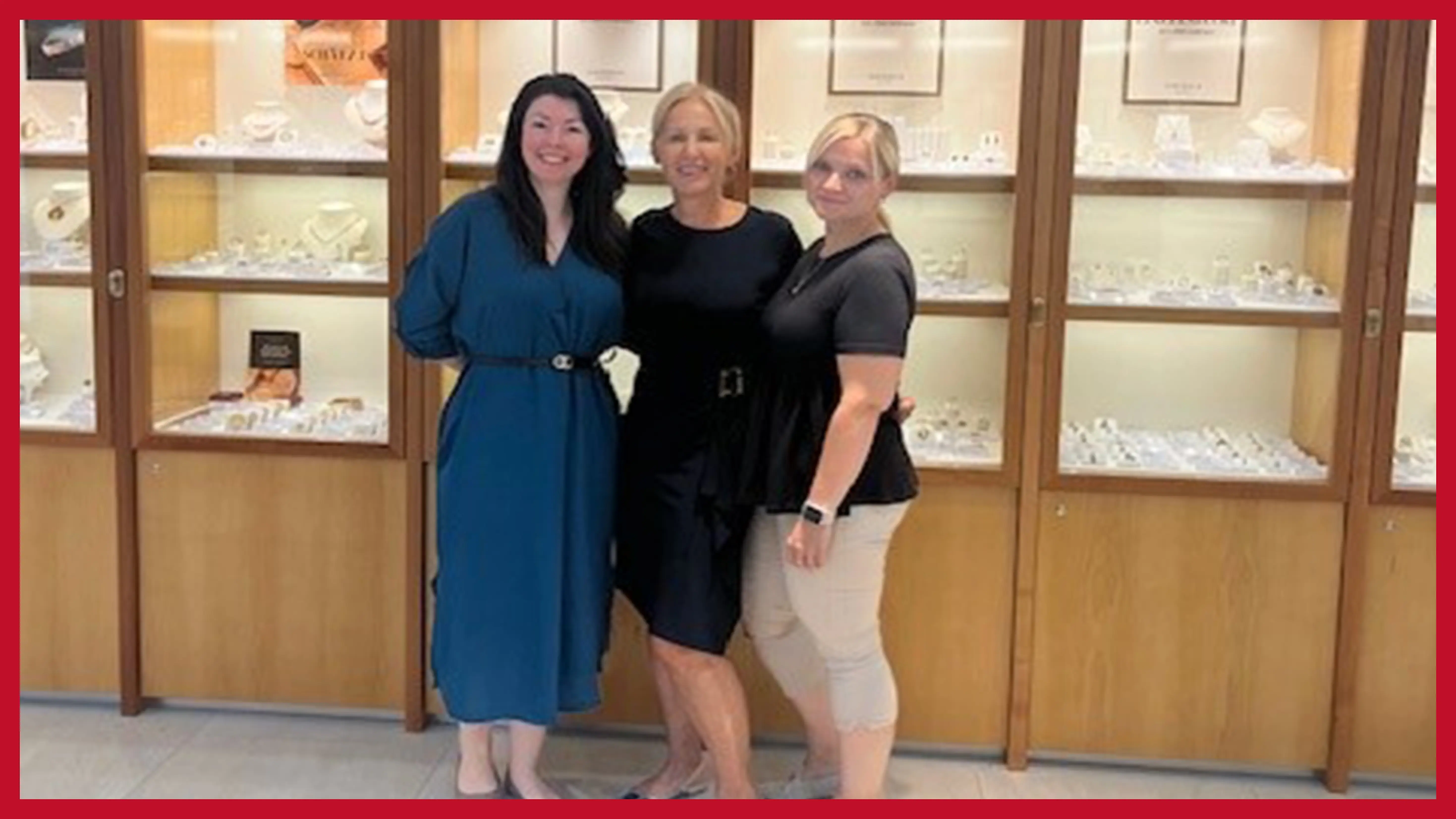 dreikoepfiges-team-vor-einer-beleuchteten-schmuckvitrine-in-der-filiale