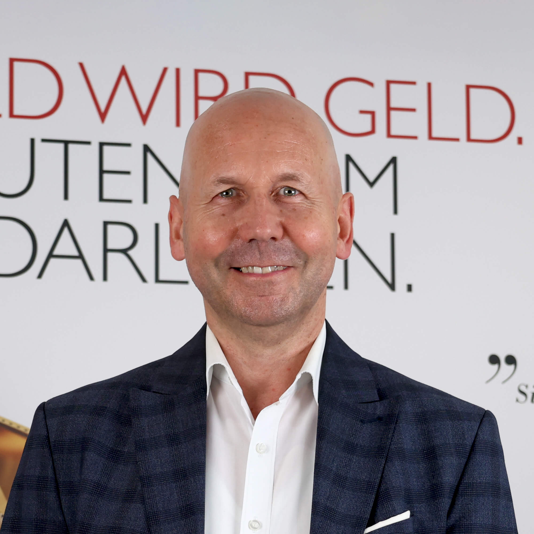 filialleiter-laechelnd-vor-poster-in-der-filiale