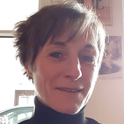 filialleiterin-laechelnd-in-schwarzem-rollkragen--vor-bildern-in-der-filiale