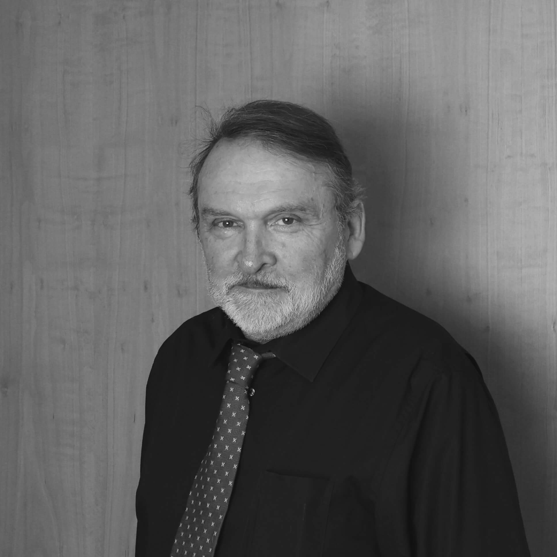 filialleiter-in-dunklem-hemd-vor-einer-wand-in-schwarz-weiß