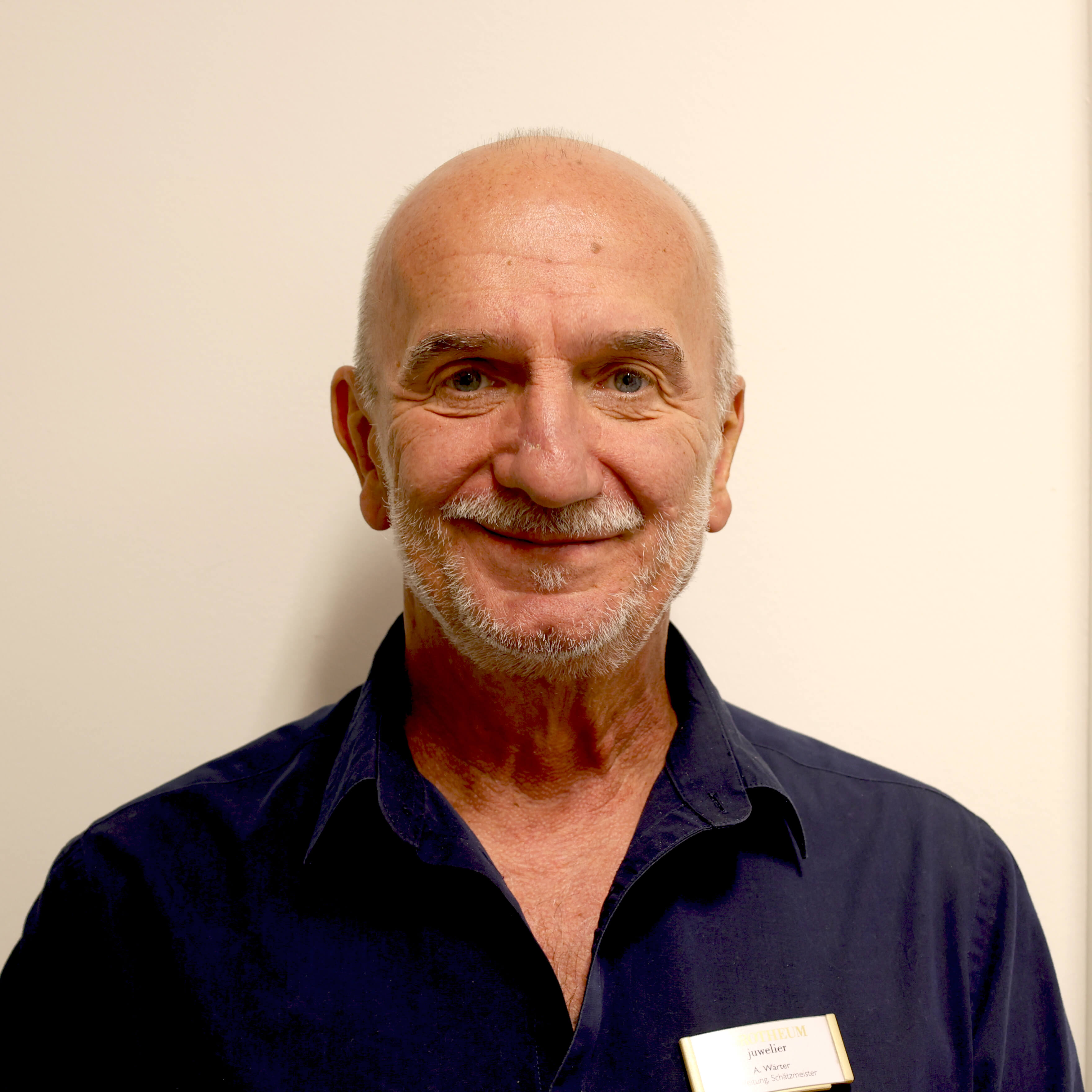 filialleiter-und-schaetzmeister-laechelnd-vor-einer-wand