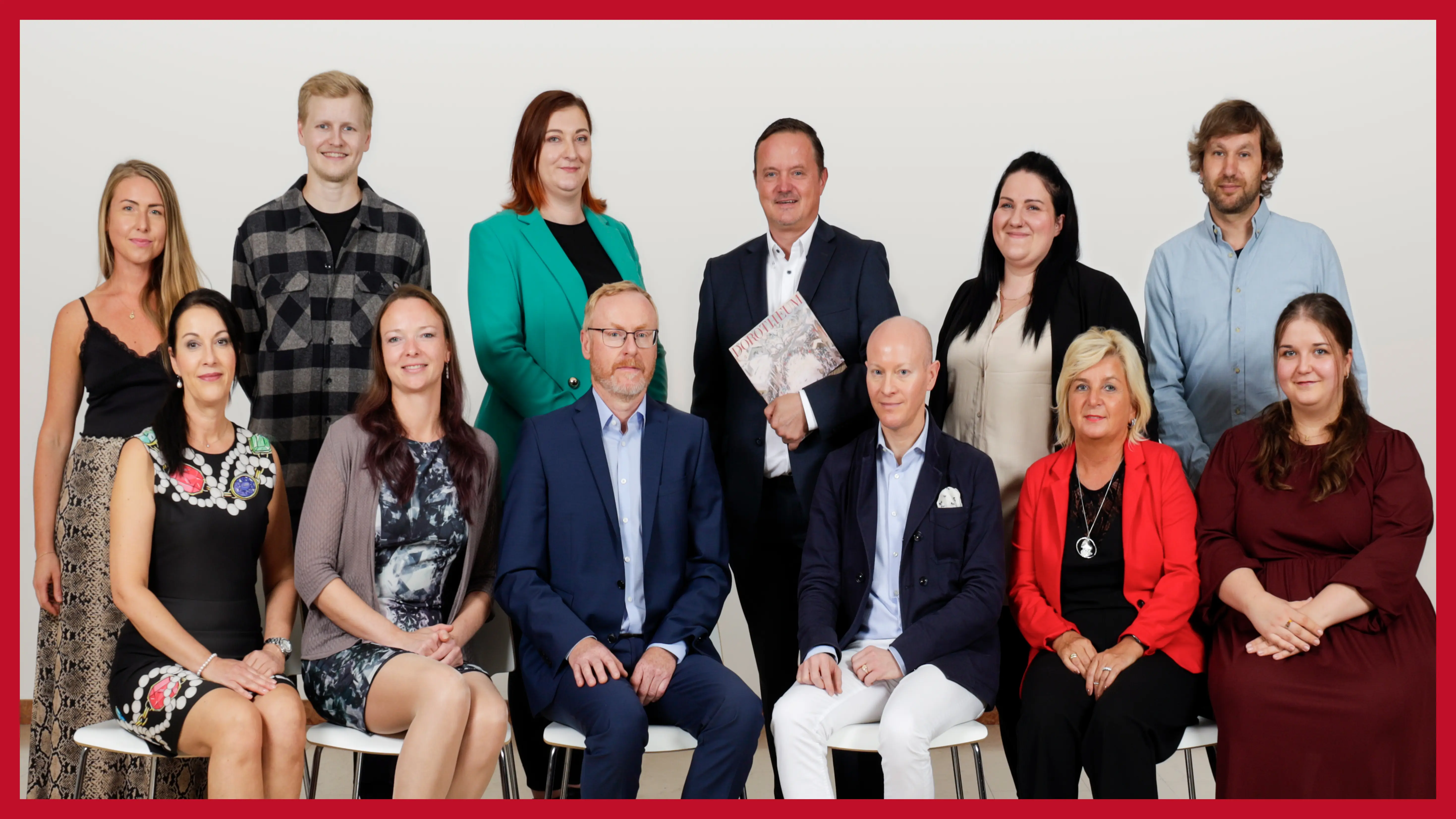 zwoelfkoepfiges-team-sitzend-und-stehen-vor-einer-grauen-wand-in-der-filiale