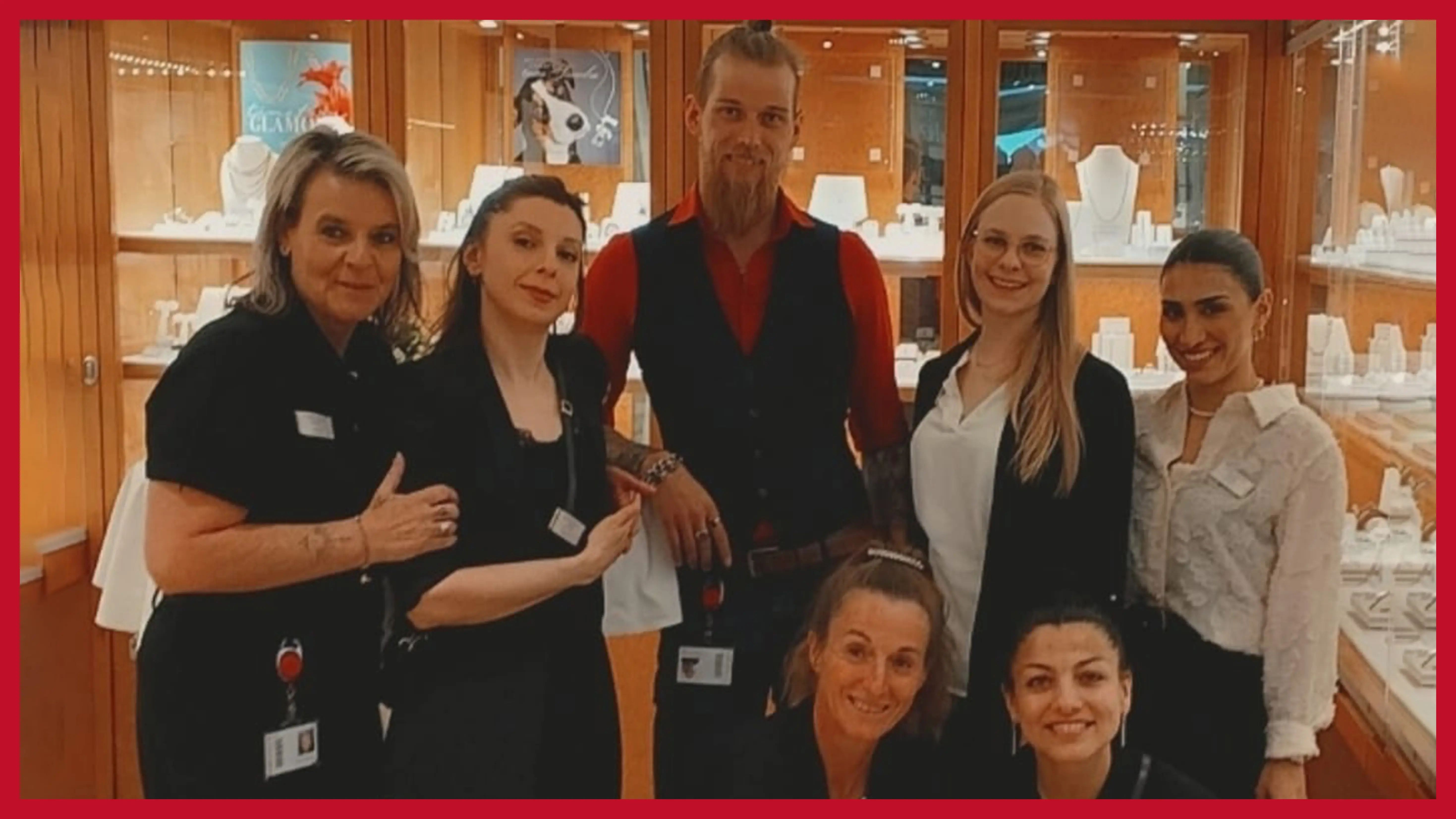 siebenkoepfiges-team-vor-einer-schmuckvitrine-in-der-filiale