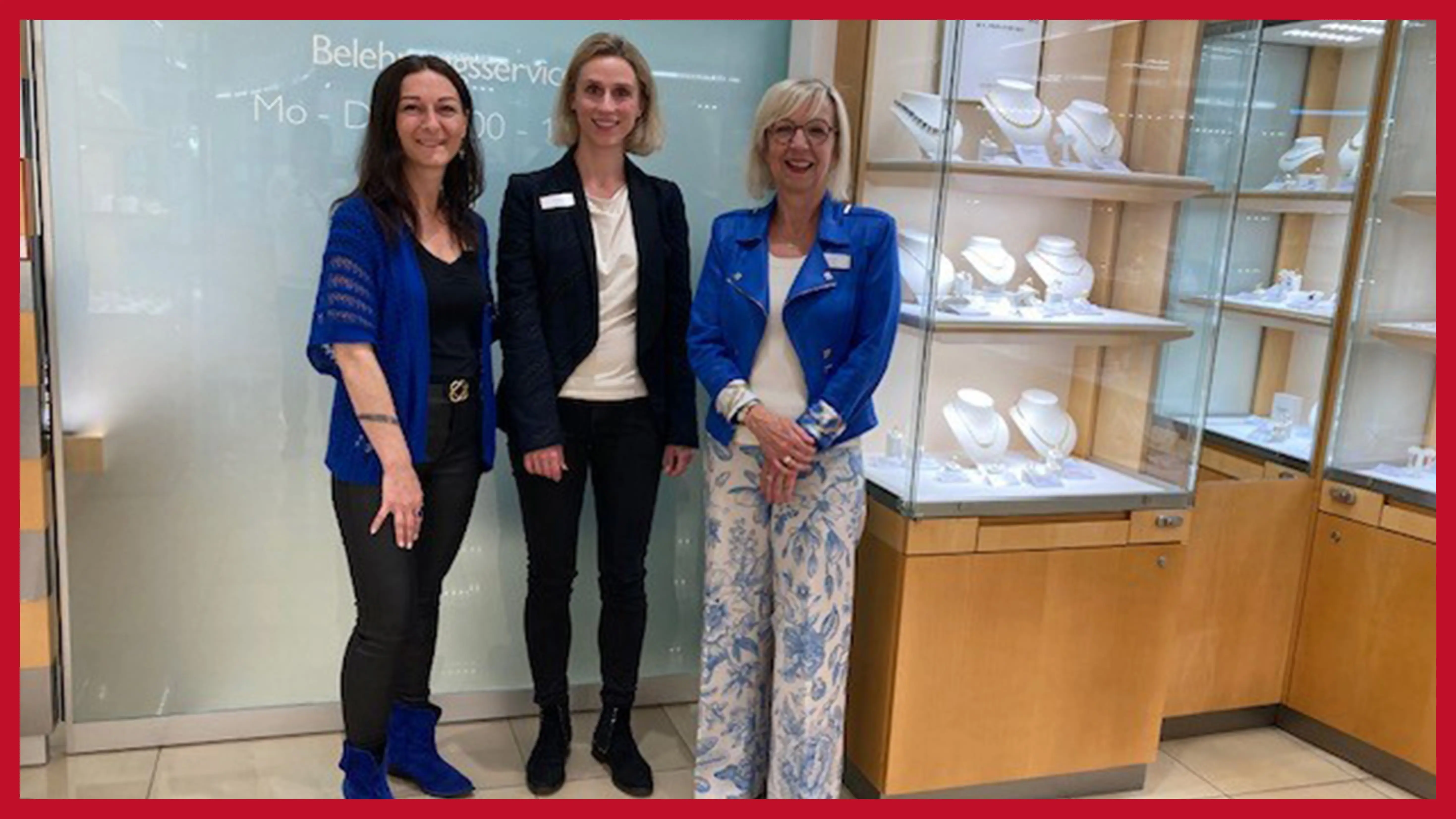 dreikoepfiges-team-in-der-filiale-vor-einer-glaswand