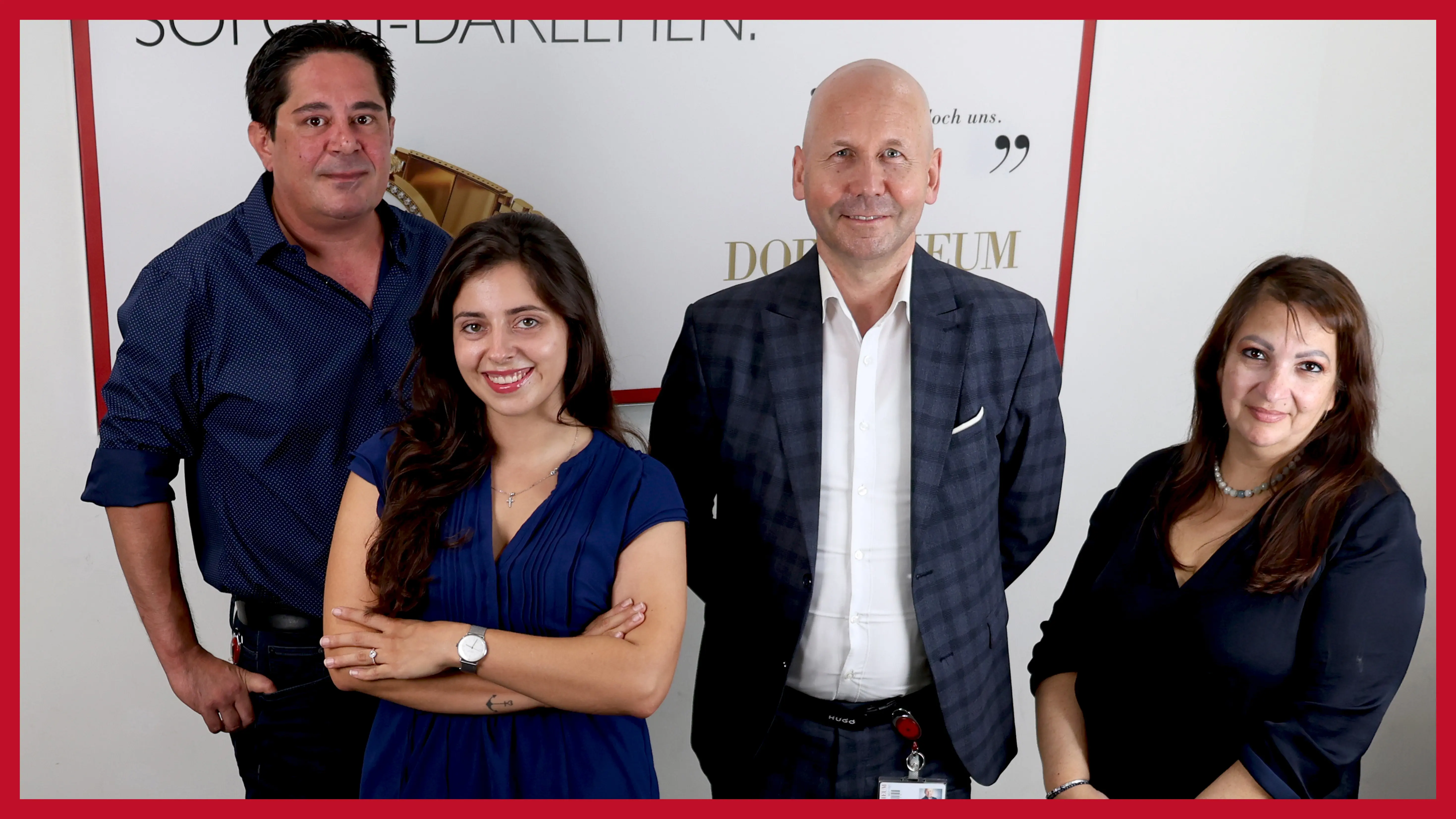 vierkoepfiges-team-vor-einem-plakat-in-der-filiale