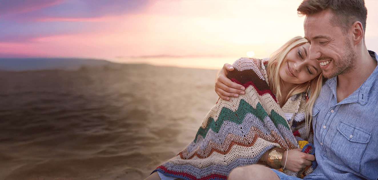 Paar am Strand mit Decke beim Sonnenuntergang- Entspannt durch den herbst mit Dorotheum Pfand
