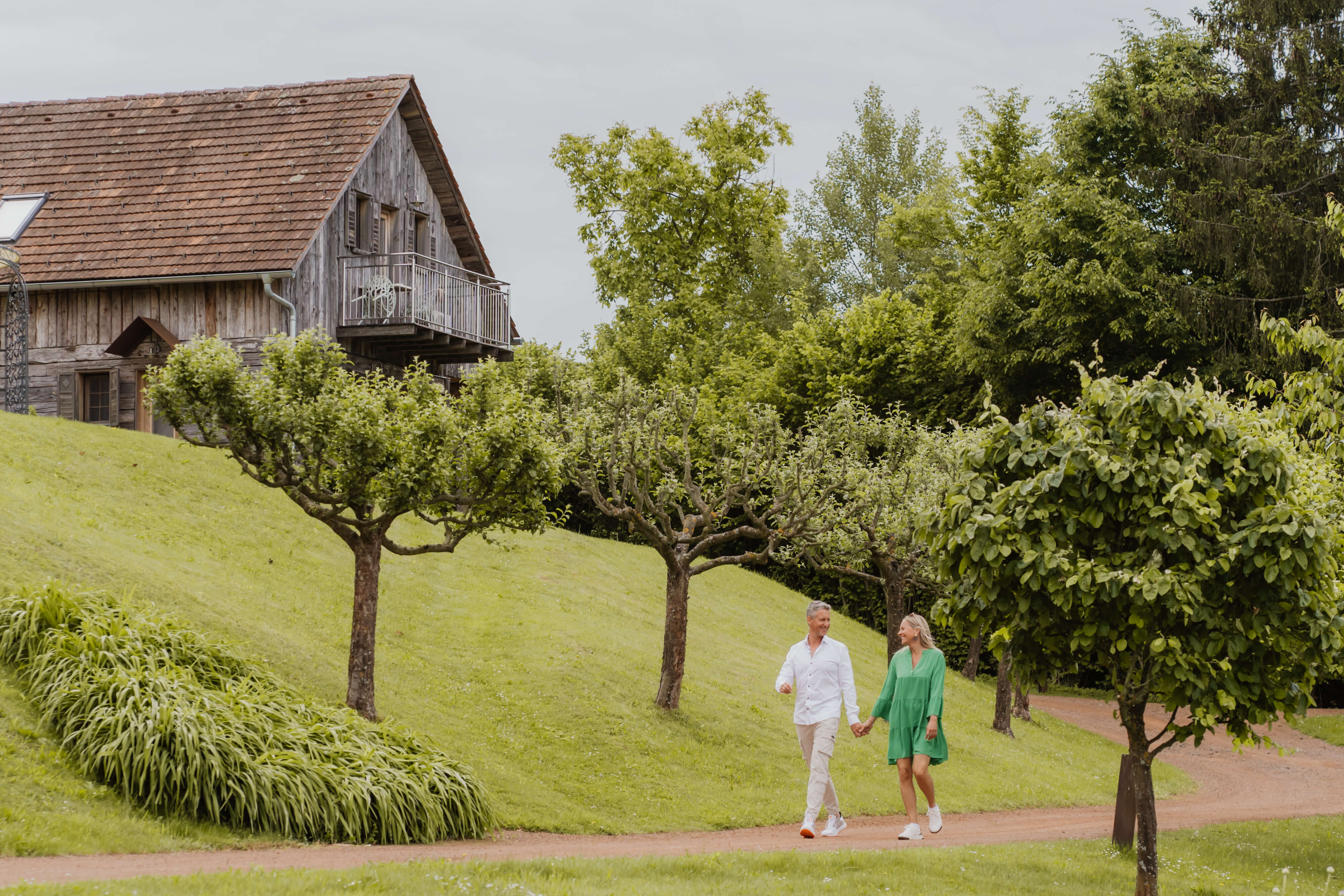 Ein Paar spaziert in der Natur das Hotel im Hintergrund