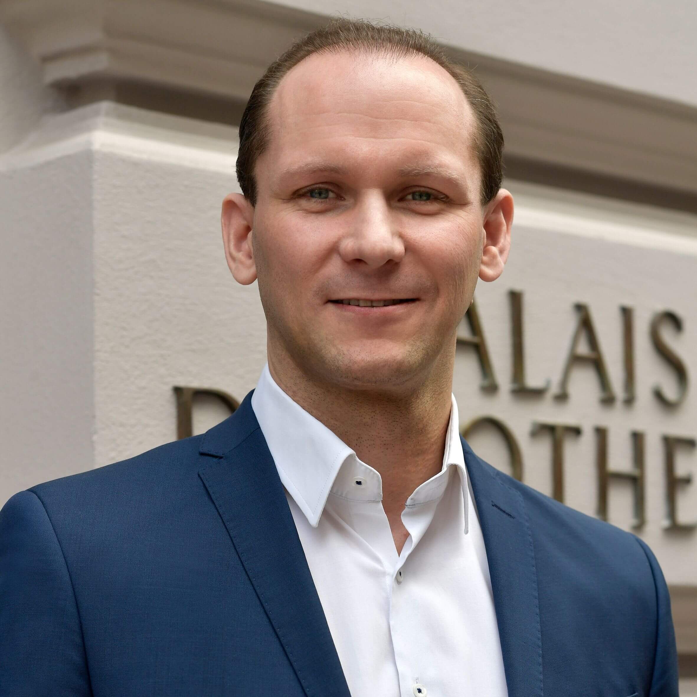 filialleiter-mit-weißem-hemd-und-blauem-anzug-vor-der-filiale