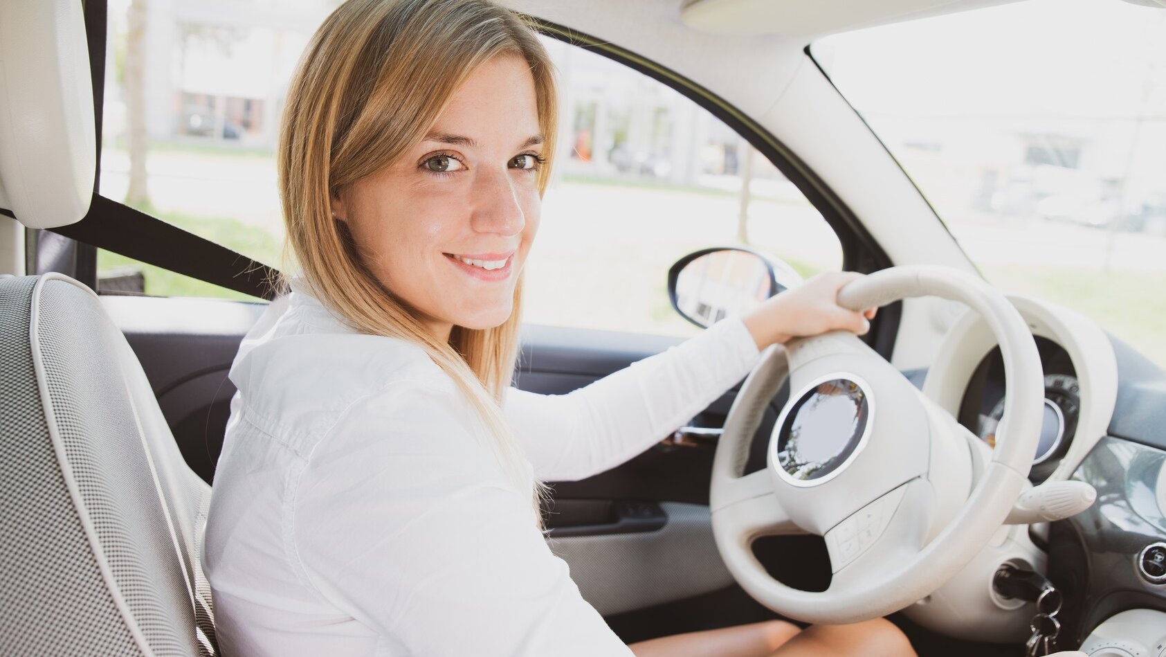 Junge Frau am Steuer ihres Autos
