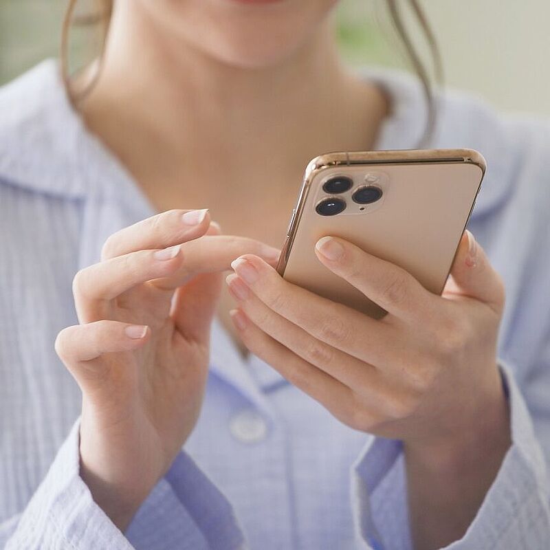 Frau bedient Smartphone für ein Technik Darlehen