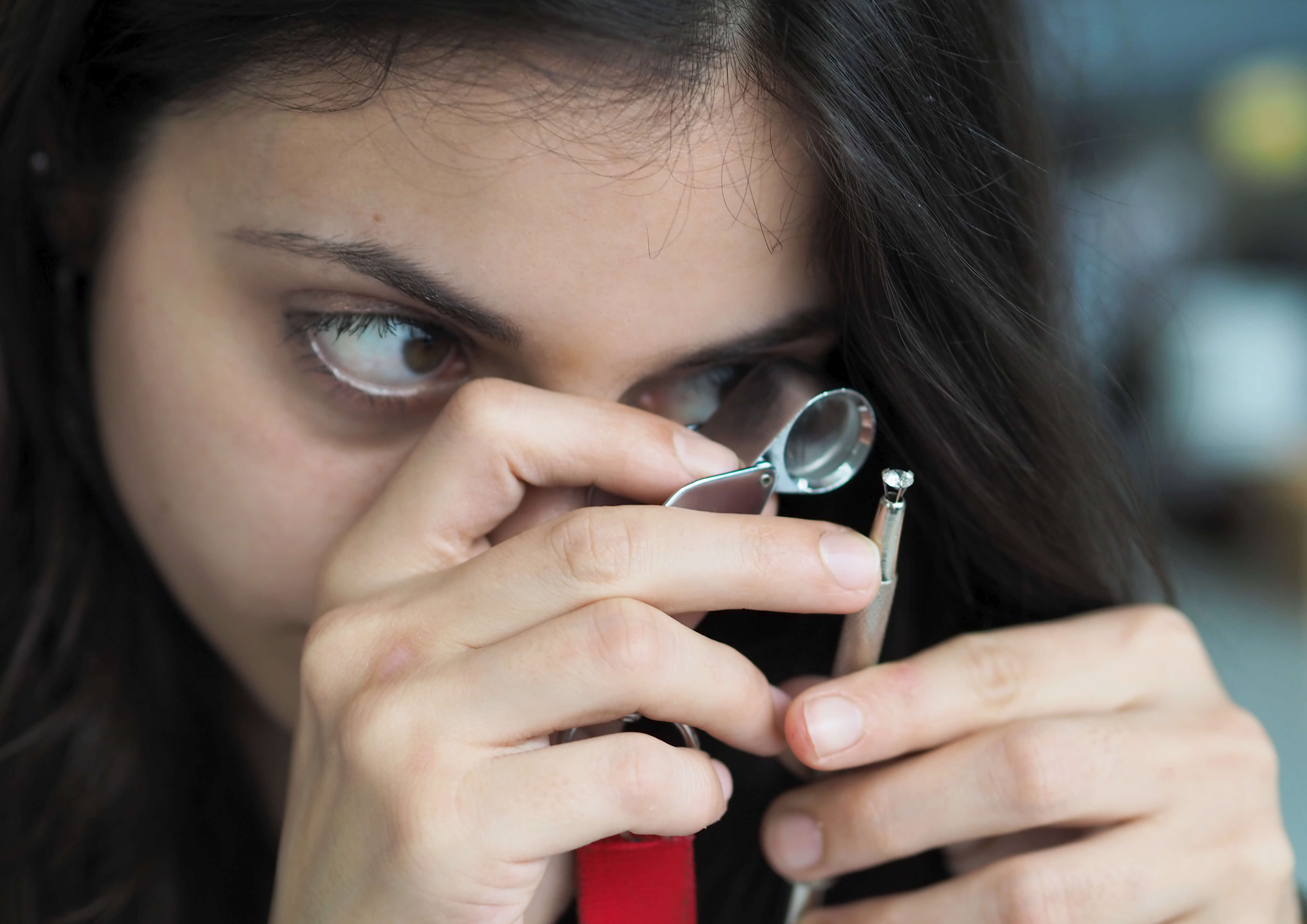 Schätzmeisterin mit Lupe und Schmuck
