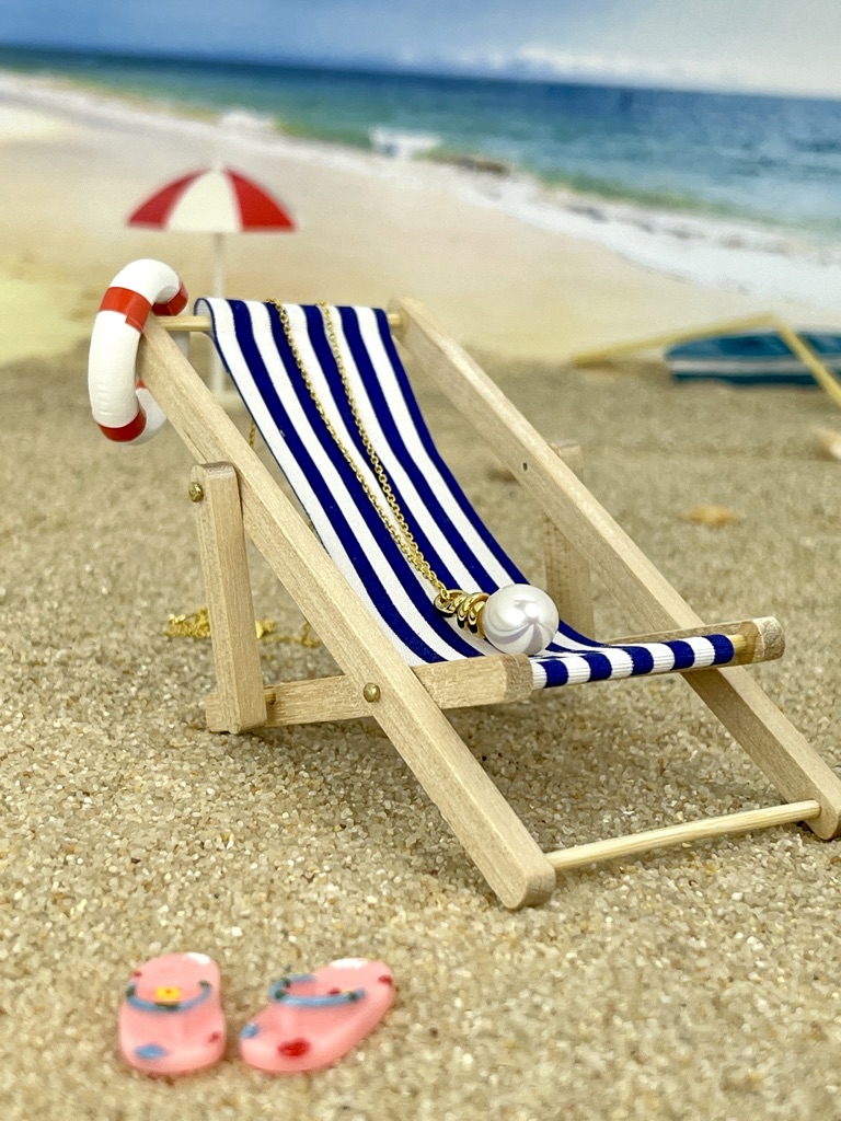 Perlenanhänger im Liegestuhl fürs Reise finanzieren